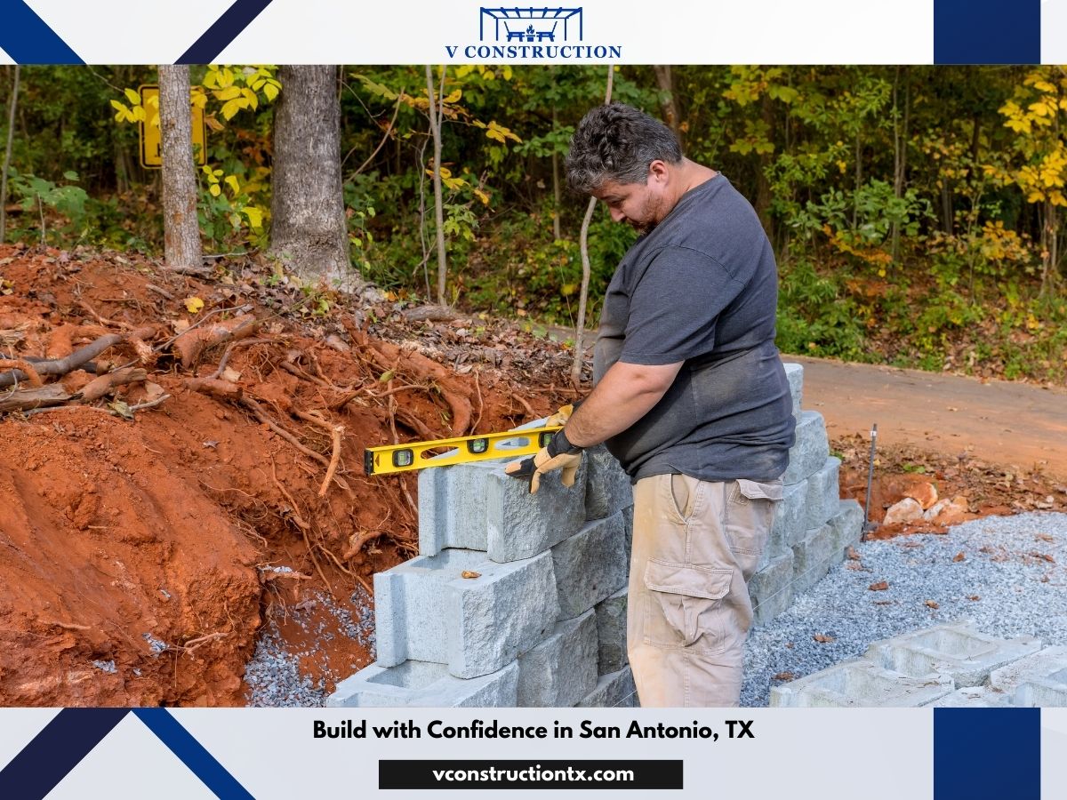 V Construction mason leveling a retaining wall block