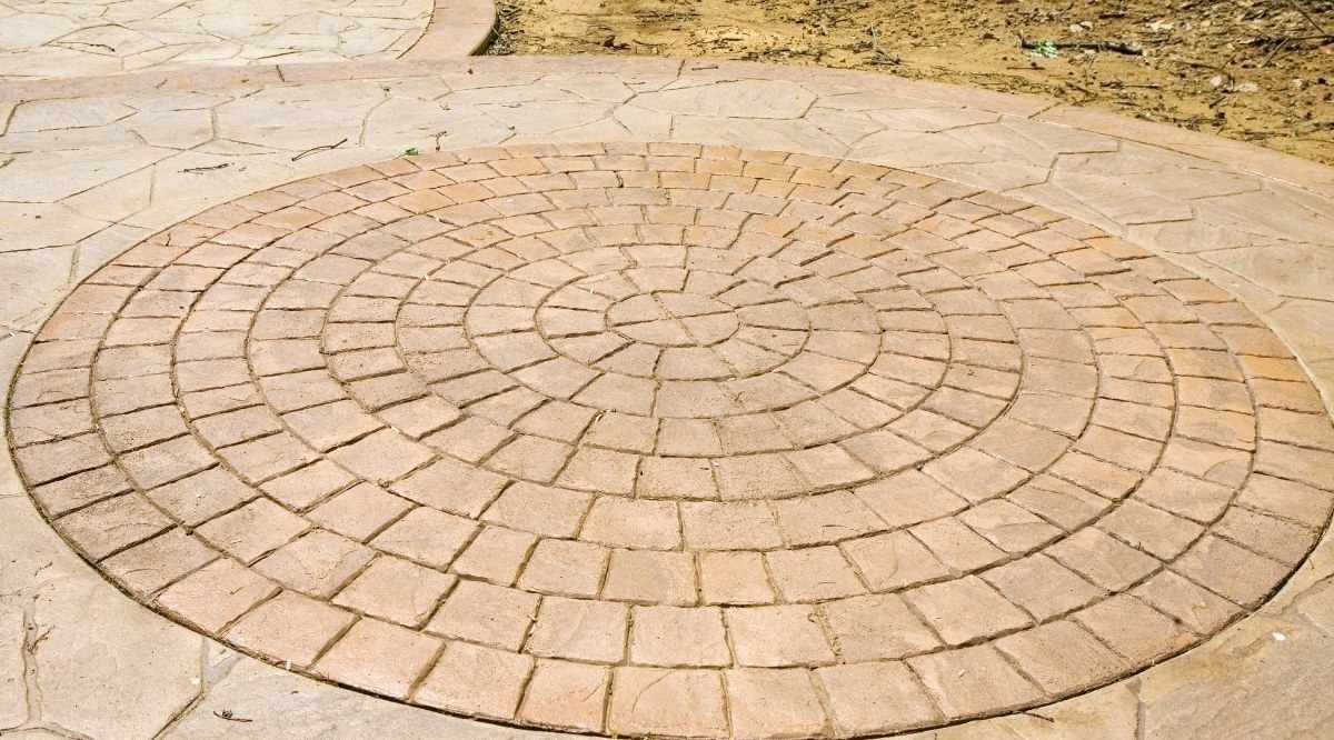 Stamped concrete patio with circular brick pattern by V Construction